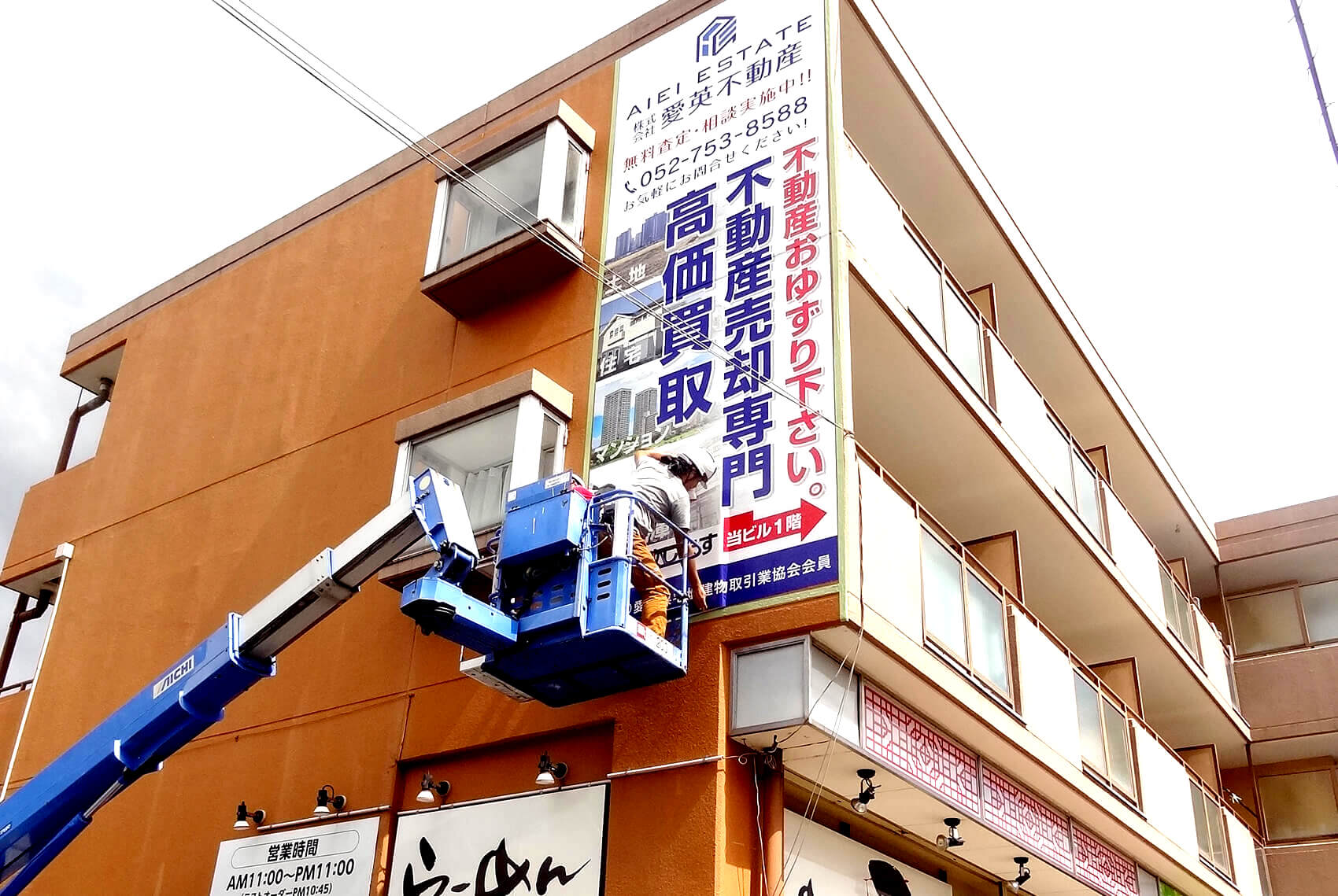 タイル張りの外壁に施工したペイントフィルムの看板。目地の凹凸に追従している